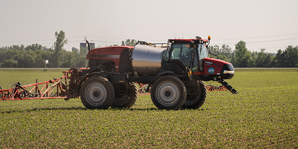 Pulvérisateur rogator à application personnalisée chargé et sortant de la tour d'engrais.