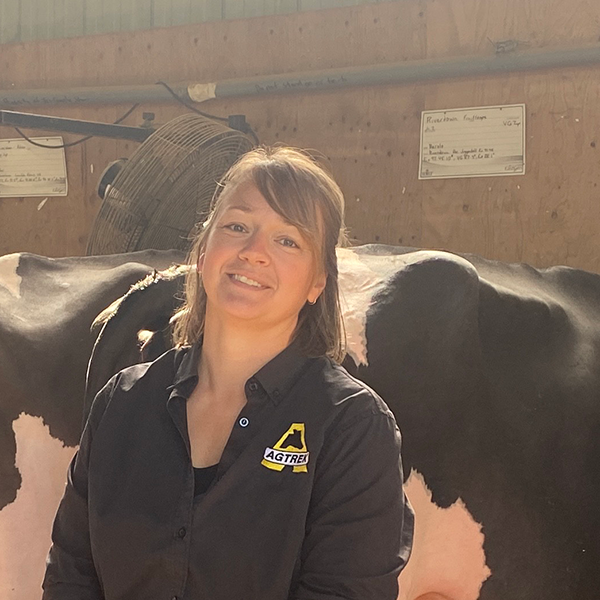 Jennifer Wubs standing next to her Co-op Embrun pick-up truck making farm visits. 